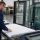 Glazier reviewing dimensions for custom-cut fire-rated glass and a commercial aluminum frame.